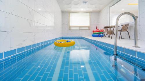 a swimming pool with a yellow raft in the middle at Gapyeong Ciere Poolvilla in Gapyeong
