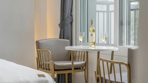 a table with a bottle of wine and two chairs at Gapyeong Ciere Poolvilla in Gapyeong