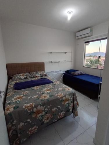 a bedroom with a bed and a window at apartamento in Tijucas