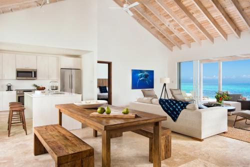 sala de estar con mesa y cocina en Sailrock South Caicos - Island Hop Flight Included en Caicos del Sur