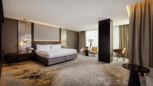 a hotel room with a bed and a desk at InterContinental - Ljubljana by IHG in Ljubljana