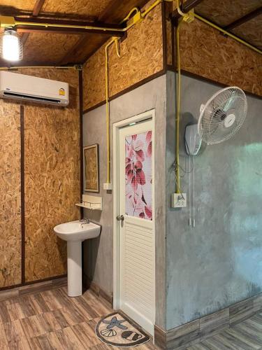 a bathroom with a shower and a toilet and a fan at Lok Mun Bungalows in Ko Yao Noi