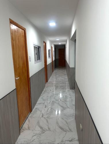 a hallway with a marble floor and a door at Hostel Luxfran in Uspallata