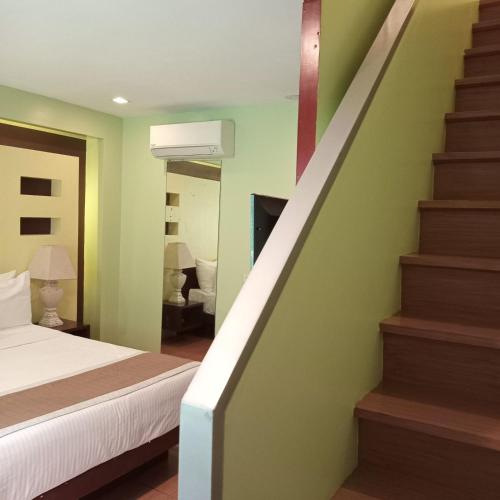 a bedroom with a bed and a stair case at Shore Time Hotel Boracay in Boracay