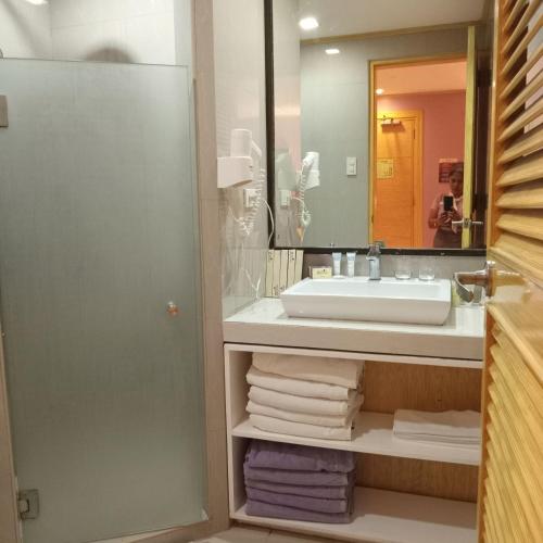 a bathroom with a sink and a mirror and towels at Shore Time Hotel Boracay in Boracay