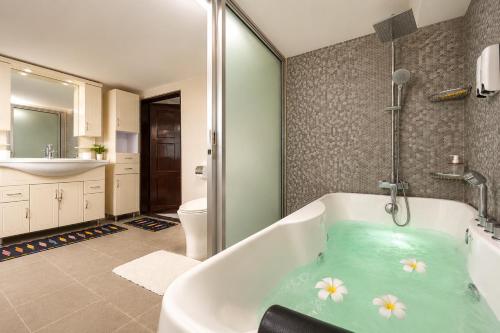 a bathroom with a bath tub with flowers in it at Galera Lodge & Cafe in Puerto Galera