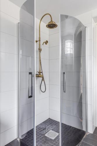 a shower with a glass door in a bathroom at Solberga red cottage in Solberga