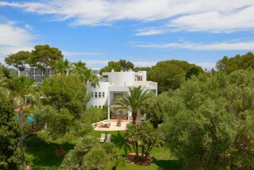 an aerial view of a white building with trees at Meliá Cala d'Or Boutique Hotel in Cala d´Or