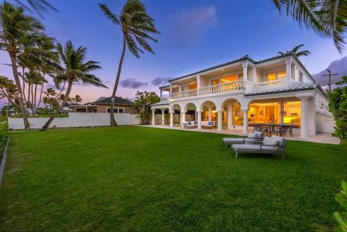a large house with a lawn in front of it at 5-star Lanikai BEACHFRONT (5 bedrooms,sleeps 13) in Kailua