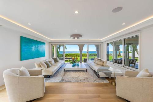 a living room with white furniture and a large window at 5-star Lanikai BEACHFRONT (5 bedrooms,sleeps 13) in Kailua