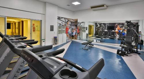 a gym with rows of tread machines and people in the background at Quality Hotel Flamboyant in Goiânia