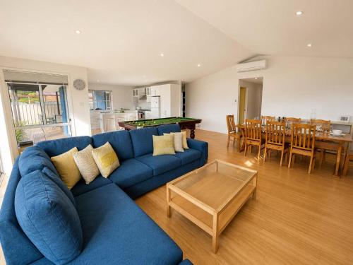 a living room with a blue couch and a table at The Coastal Haven in Manyana