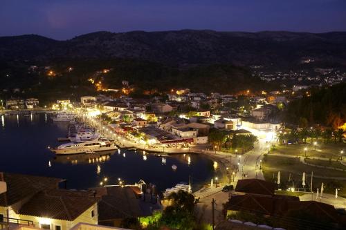a city at night with boats in the water at Panorama Botsaris Apartments in Sivota