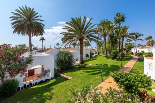 a view of the backyard of a house with palm trees at SOL by Meliá Barbacan in Playa del Ingles