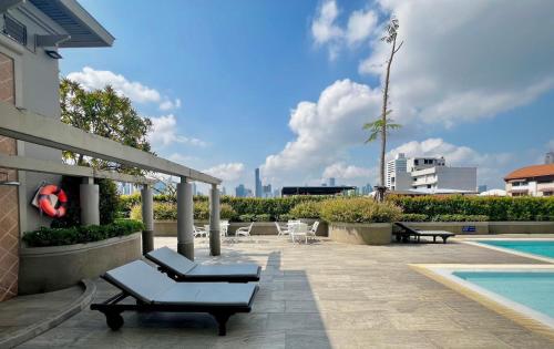 a patio with lounge chairs and a swimming pool at BU Place Hotel in Bangkok