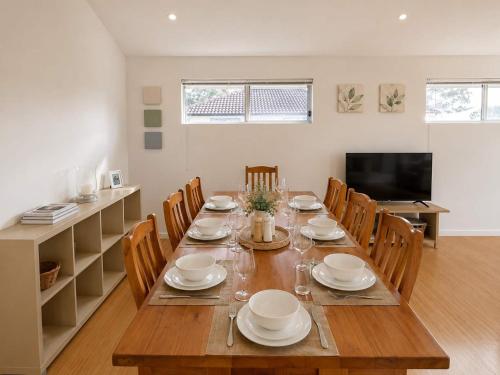 a dining room with a wooden table and chairs at The Coastal Haven in Manyana