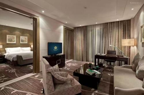 a hotel room with a bed and a living room at The Jade Boutique Hotel in Wuhan