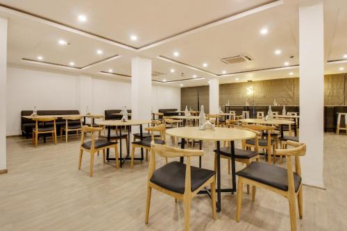 a restaurant with tables and chairs in a room at Super townhouse moosapet Rcc Prime in Hyderabad