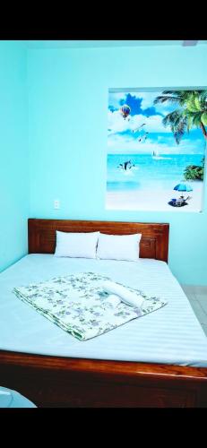 a bedroom with a bed with a painting on the wall at 846 A12 Bùi Thiện Ngộ in Cù Lao Tâu