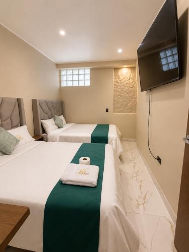 a hotel room with two beds and a flat screen tv at Libertad Grand Hotel in Ayacucho