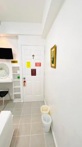 a bathroom with a white door and a sink at Villa Adela Pension House in Balamban
