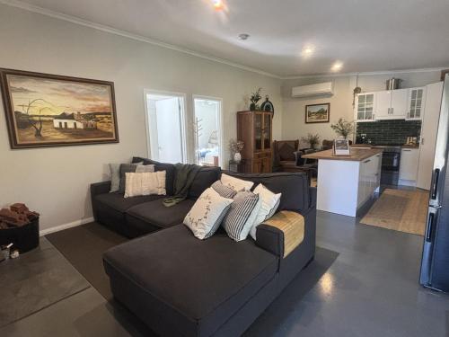 a living room with two couches and a kitchen at Riverfront, Tiny Home in Natural Bush in Bridgetown