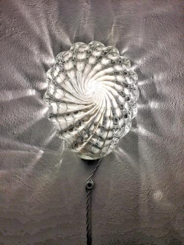 a silver shell on top of a bed at Le dimore de Il borgo del balsamico in Albinea