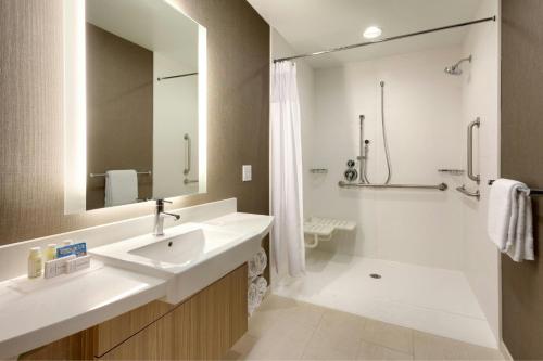 a bathroom with a sink and a mirror and a shower at SpringHill Suites by Marriott Moab in Moab