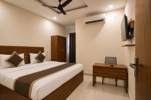 a hotel room with a bed and a television at Hotel Gokul Pride Near Secunderabad Railway station in Hyderabad