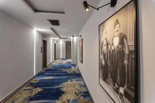 a hallway with a blue and gold carpet and framed art at Shkodër Grand Hotel Europa, Affiliated by Meliá in Shkodër