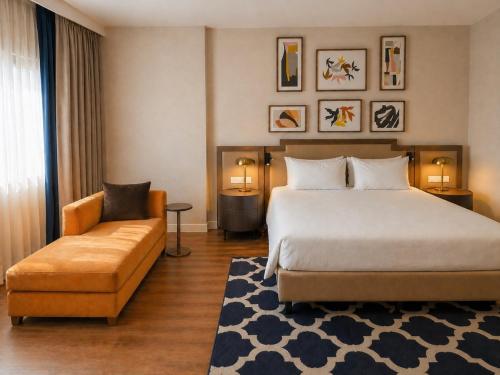 a hotel room with a bed and a couch at voco Madrid - Las Tablas by IHG in Madrid