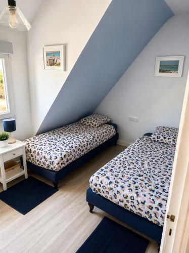 two beds in a room with blue and white walls at An Dorzell beach 60 meters in Cléder