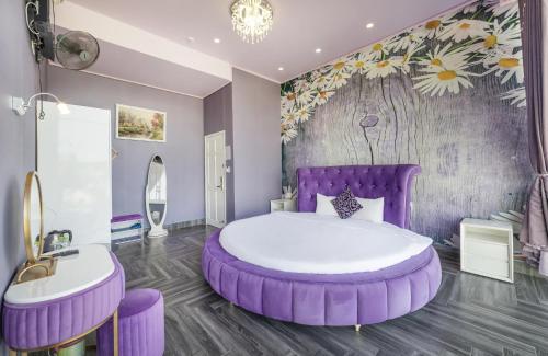 a purple bedroom with a large bed and a sink at Mac Valley DaLat Hotel in Da Lat