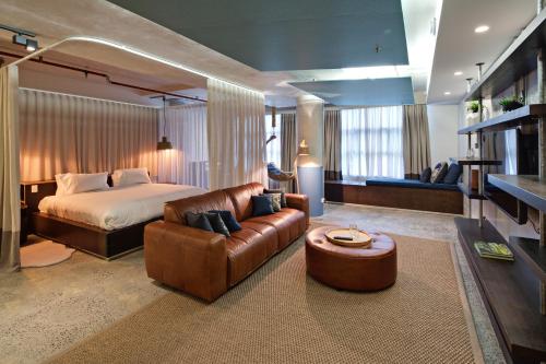 a bedroom with a bed and a couch and a chair at Zara Tower – Luxury Suites and Apartments in Sydney