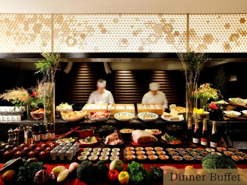 two people in a kitchen with a buffet of food at The HOTEL SANRAKU KANAZAWA in Kanazawa