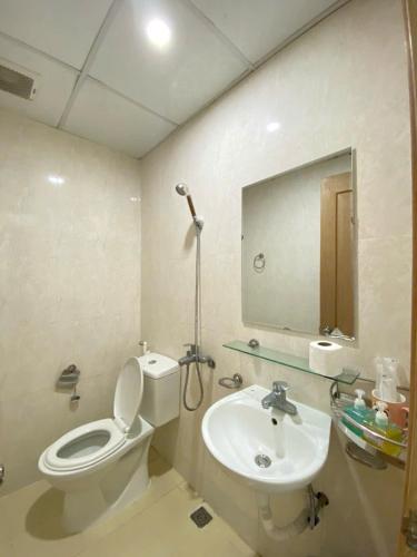 a bathroom with a toilet and a sink and a mirror at Da nang seaview MT apartment in Danang