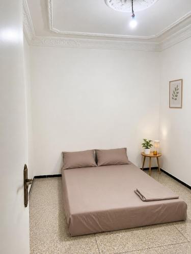 a bedroom with a bed in a white room at Perfect home in Temara