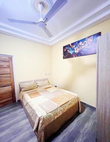 a bedroom with a bed and a ceiling fan at Fofana Luxury Suites in Sotuom