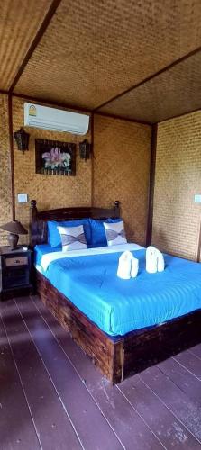 a bedroom with a bed with two towels on it at ปายเรือนไทย in Pai