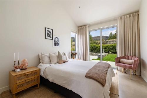 a bedroom with a large bed and a window at Pavilion-Style Residence Queenstown in Queenstown