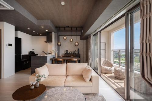 a living room with a couch and a table at JAPAVISTA Casa De Boss in Naha