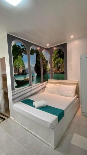 a bedroom with a large bed with a view of the water at Villa Adela Pension House in Balamban