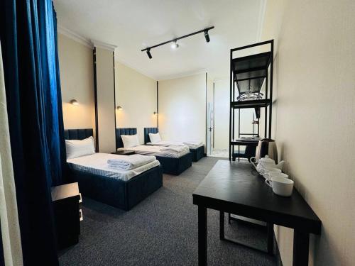 a hotel room with two beds and a table at Backpackers Tashkent in Tashkent