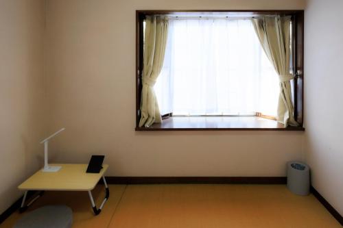 a room with a mirror and a table and a window at Mikansei Stay in Higashi-murayama