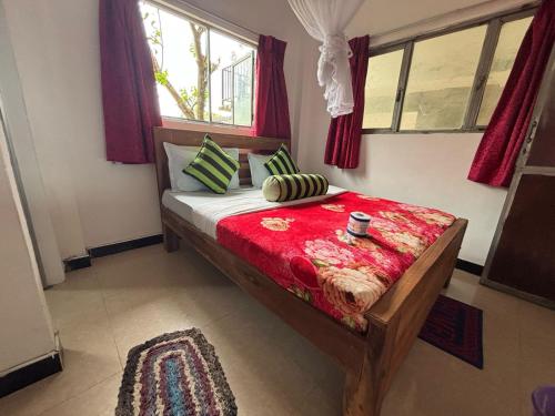 a bedroom with a bed with a red comforter at Green View Resort in Ella