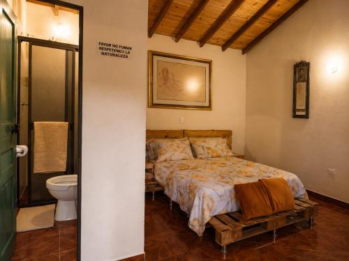 a bedroom with a bed and a toilet at Ecohotel El Amarradero in Alejandría