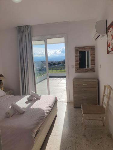 a bedroom with a bed and a view of a balcony at G&E Harbour Apartments in Lachi