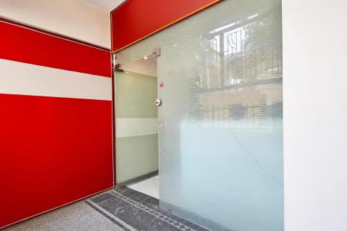 a red door in a room with a window at Super Hotel O Gorakhpur Railway Junction Road Golghar Formerly RR Inn in Gorakhpur