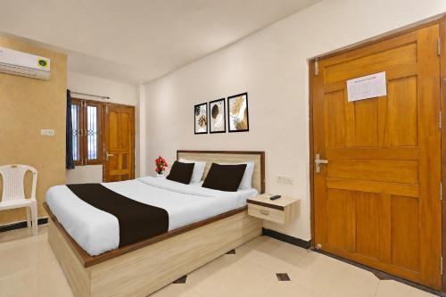 a bedroom with a bed and a wooden door at Super Hotel O Gorakhpur Railway Junction Road Golghar Formerly RR Inn in Gorakhpur