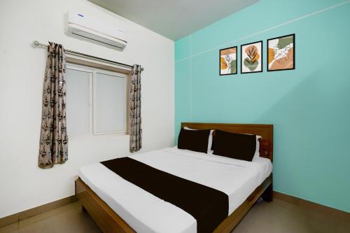 a bedroom with a large bed with a window at Super Collection O DLF CyberCity Hyderabad Formerly Key Suites in Kondapur